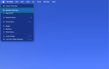 Mac desktop showing the System Settings option in the menu.